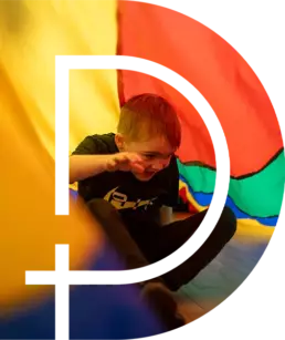 A child playing under a large canopy at Kids performing Irish Dancing at St Columba's Derrvolgie Community Hall