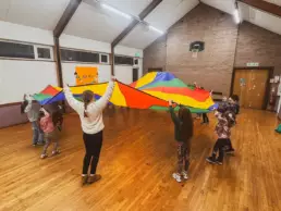 Kids playing with colourful parachute