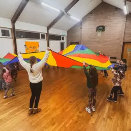 Kids playing with colourful parachute