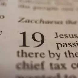 Close-up of an open Bible showing verse number 19, highlighting scripture text about Jesus and faith