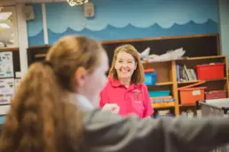 Play therapist engaging with a child during a play therapy session in a school setting.