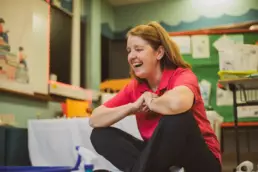 Play therapist sitting with a child during a creative play therapy activity.