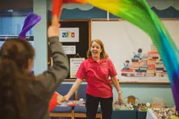 Play therapist leading a creative play therapy activity with a child in a school setting.