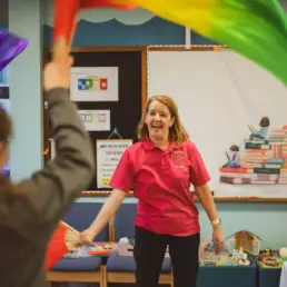 Play therapist leading a creative play therapy activity with a child in a school setting.