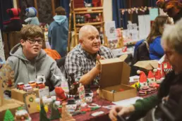 Visitors chatting with stallholders amid fairy lights and handmade gifts at Derryvolgie Twilight Market