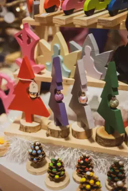 Hand-painted wooden Christmas decorations and festive figures on display at the Twilight Market