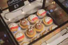 Festive Christmas cupcakes decorated as snowmen and reindeer on display at the Twilight Market